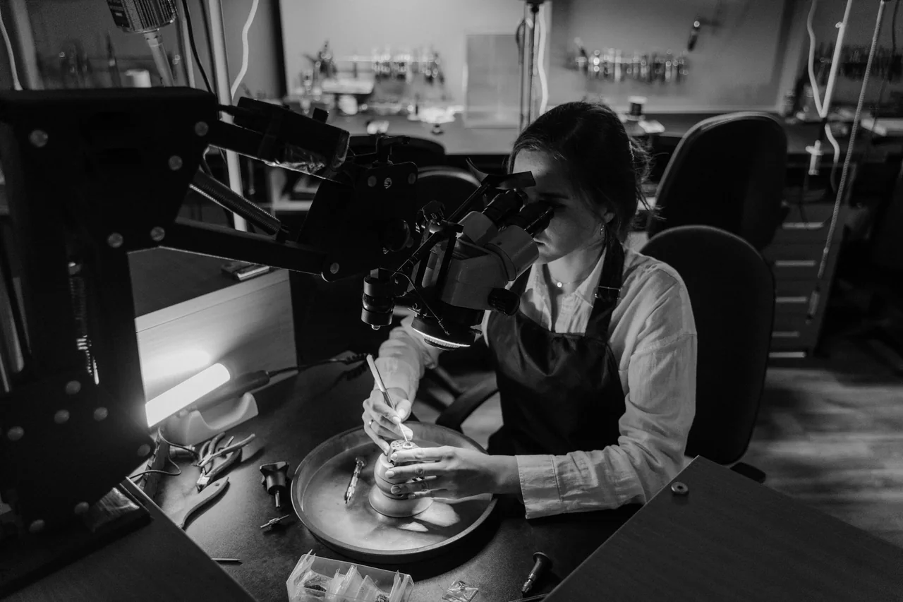 Jeweller working at a bench under a microscope